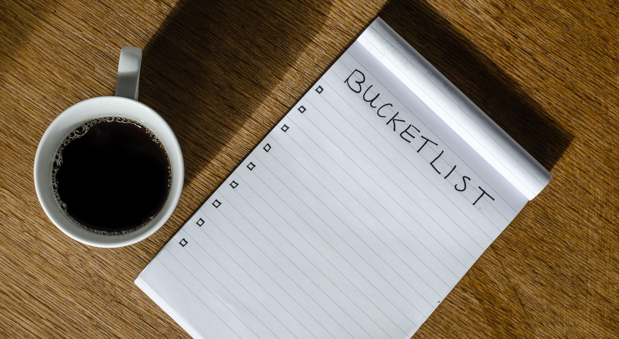 Bucket list notepad and cup of coffee