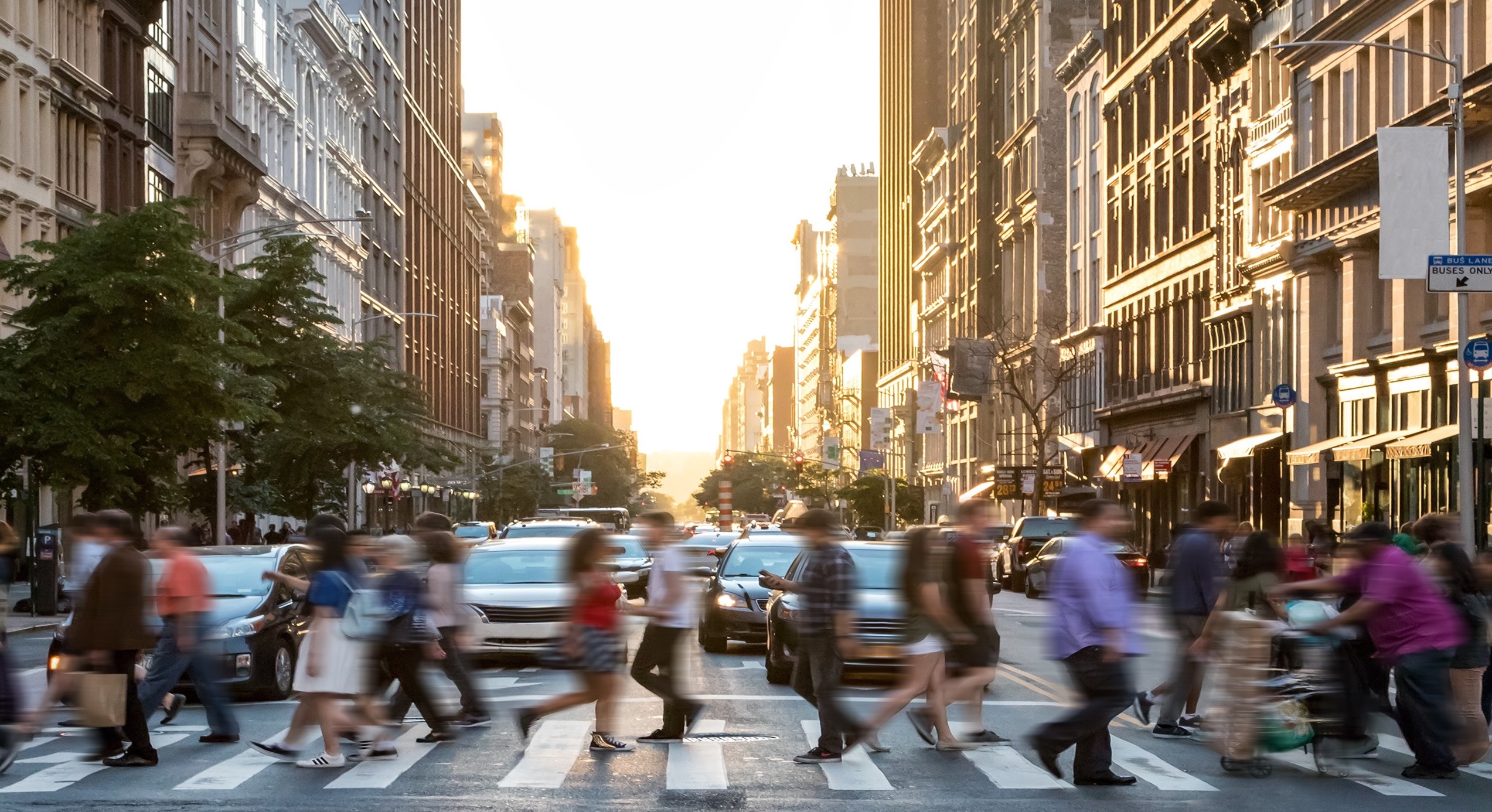 People walking across a street in a busy city