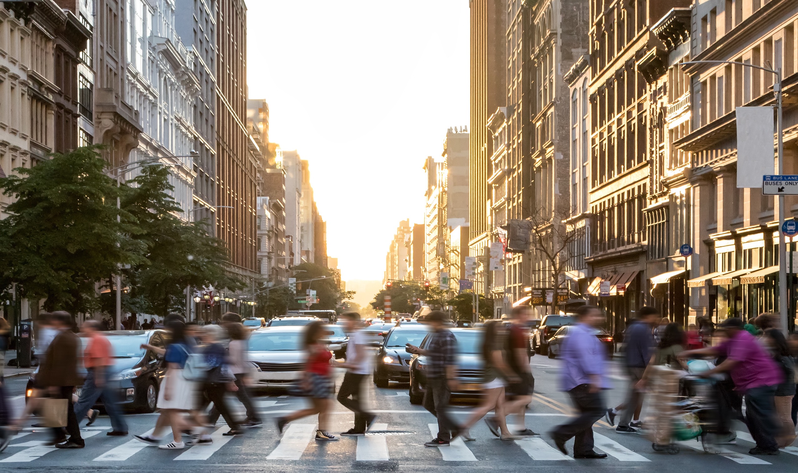 People walking across a street in a busy city